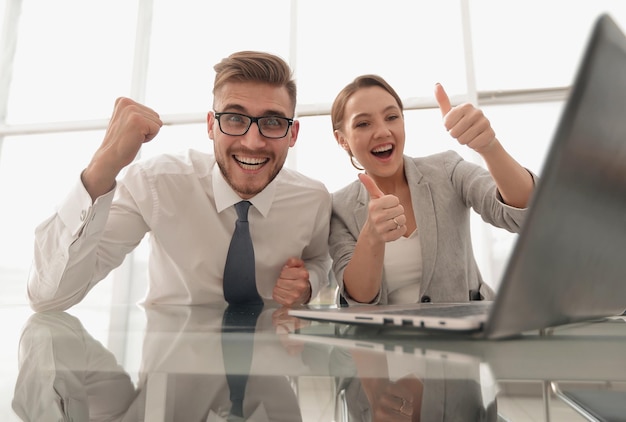 Heureux collègues d'affaires assis à leur Deskphoto avec espace de copie