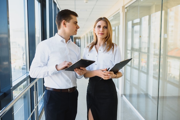 Heureux collègues de bureau dans un bureau moderne à l'aide de tablette