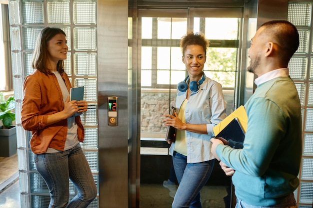 Heureux collègues gais bavardant et riant sur le lieu de travail