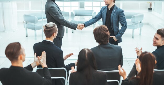 Heureux collègues se serrant la main. rencontres et partenariats