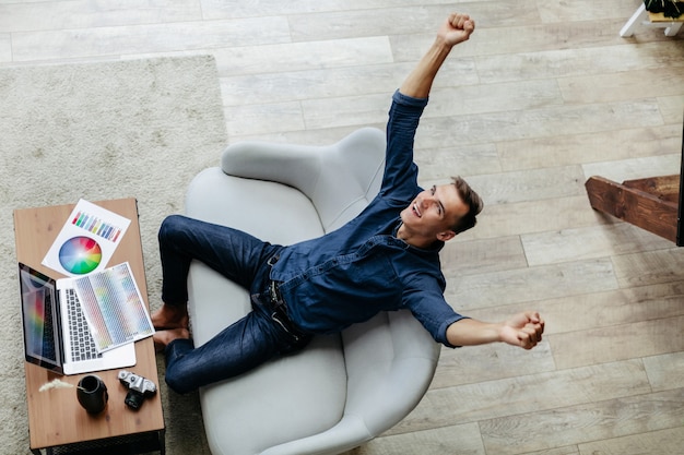 Heureux concepteur masculin assis à son bureau