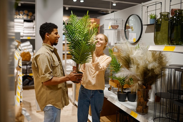 Heureux couple achetant un palmier en pot décoratif