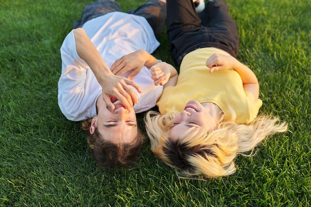 Heureux couple d'adolescents sur l'herbe verte