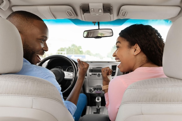 Heureux couple afro-américain criant oui dans une nouvelle auto