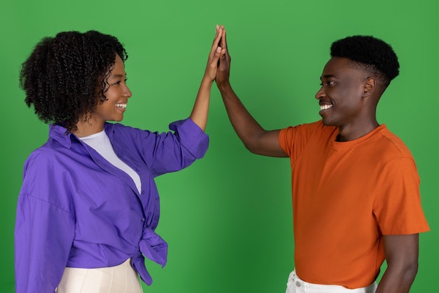 Photo heureux couple afro-américain du millénaire en décontracté célébrant la victoire et le succès