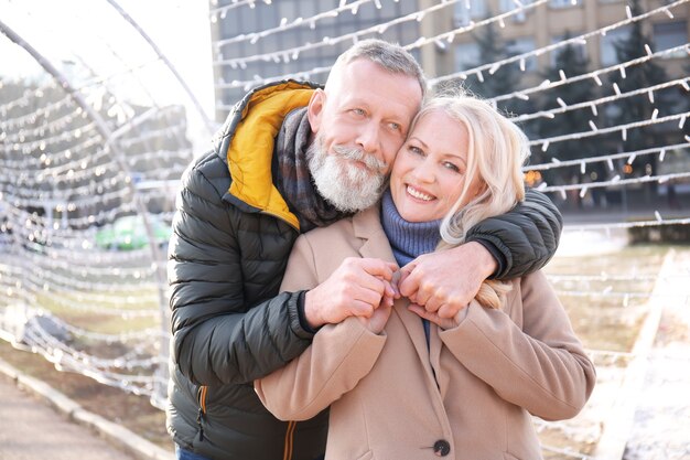 Heureux couple d'âge mûr embrassant à l'extérieur