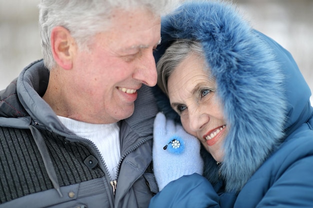 Heureux couple d'âge mûr posant en plein air en hiver