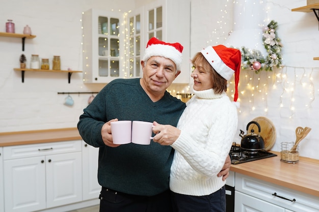 Heureux Couple D'âge Mûr Prenant Son Petit Déjeuner Dans La Cuisine De Noël à La Maison