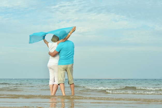 Heureux couple d'âge mûr profiter de l'air frais sur la plage