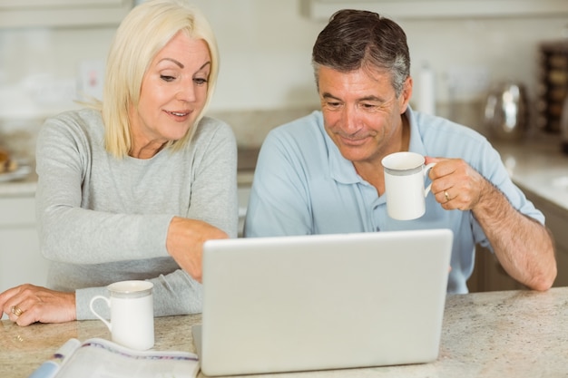 Heureux couple d&#39;âge mûr utilisant un ordinateur