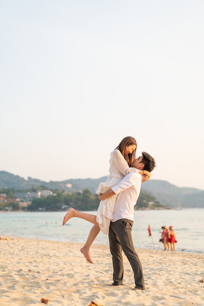 Heureux couple aller voyage de noces sur la plage de sable tropicale en été