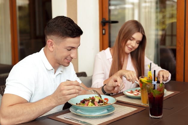 Heureux couple d'amoureux appréciant le petit déjeuner dans un café.