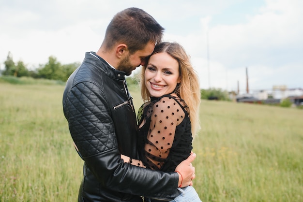 Heureux couple amoureux au coucher du soleil et souriant