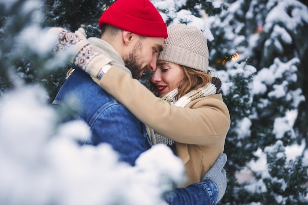 Heureux couple amoureux dans la forêt d'hiver