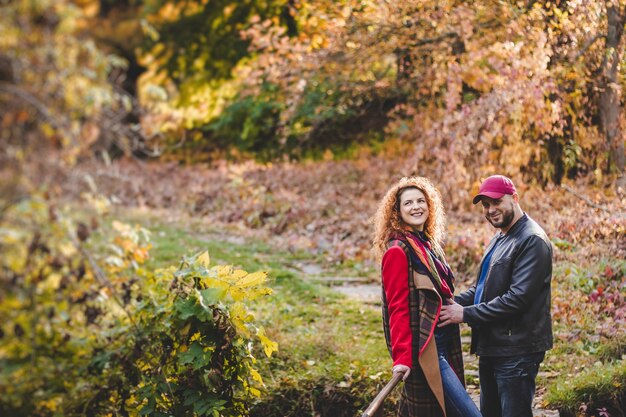 Heureux couple amoureux embrasse et s'amuse à l'extérieur dans le fond de la nature. La femme est enceinte. Heureux nouveaux parents.