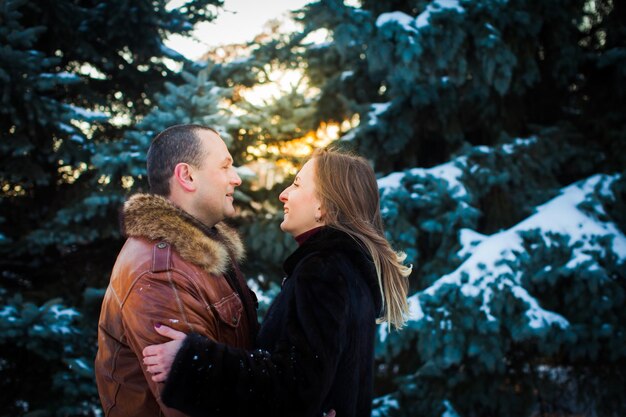 Heureux couple amoureux embrasser dans la forêt froide d'hiver enneigé Concept d'amour et de relation