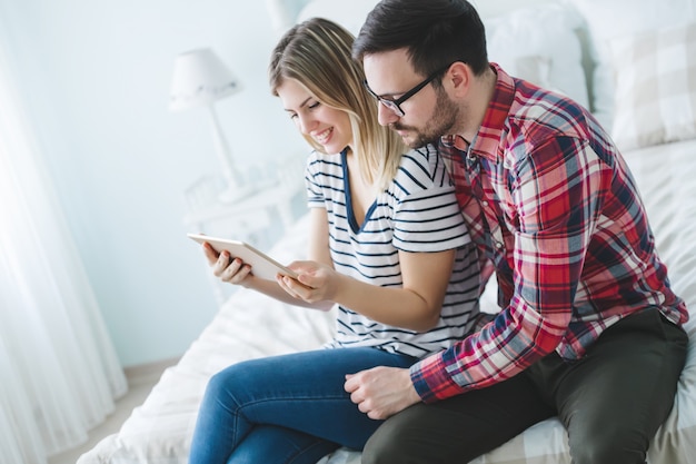 Heureux couple amoureux faisant du shopping en ligne à la maison