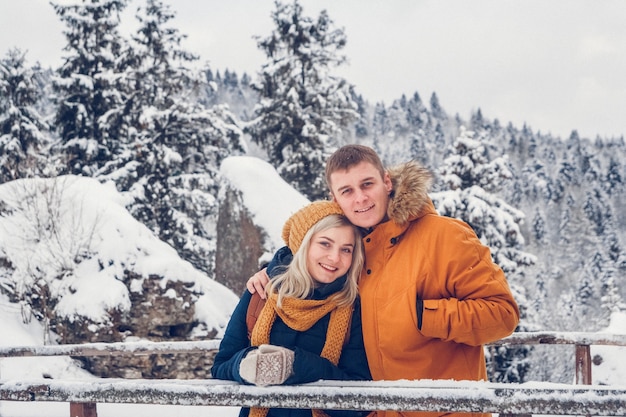 Heureux couple d'amoureux marchant dans le parc d'hiver profitant de la neige. Espace pour le texte