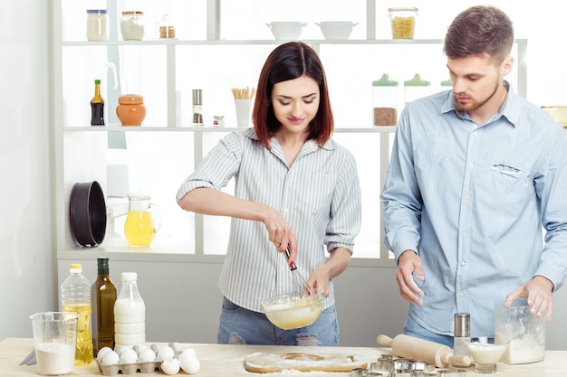 Heureux couple amoureux de la pâte à cuire dans la cuisine