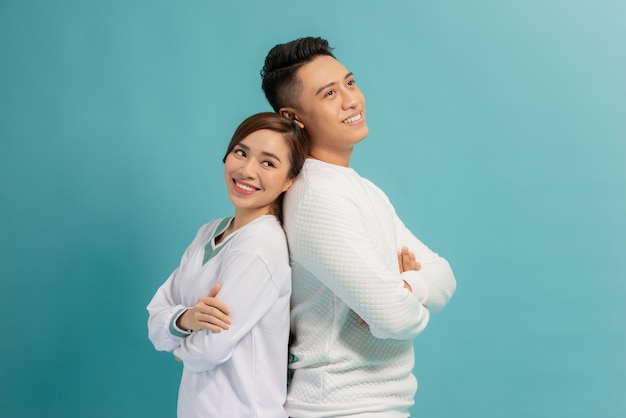 Heureux couple d'amoureux. Photo de Studio de beau jeune couple debout dos à dos et souriant