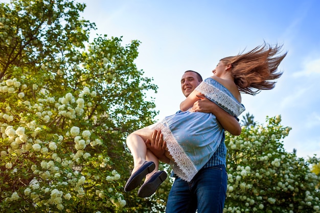 Heureux couple amoureux s'amuser dans un jardin fleuri