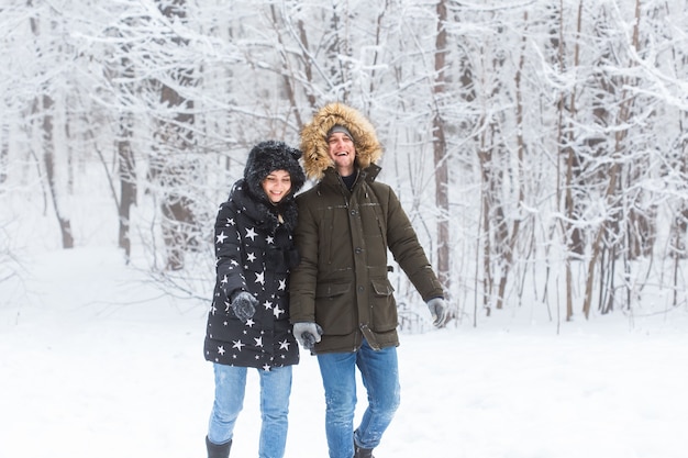 Heureux couple d'amoureux s'amuser en plein air dans le parc à neige. Vacances d'hiver.