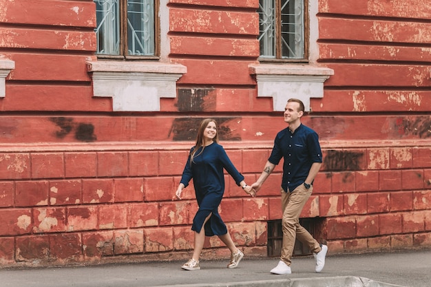 L'heureux couple amoureux se promène ensemble dans les rues de la ville. Un couple charmant dans les vieilles rues étroites de la ville. Mode de vie des gens souriants. Notion de relations familiales