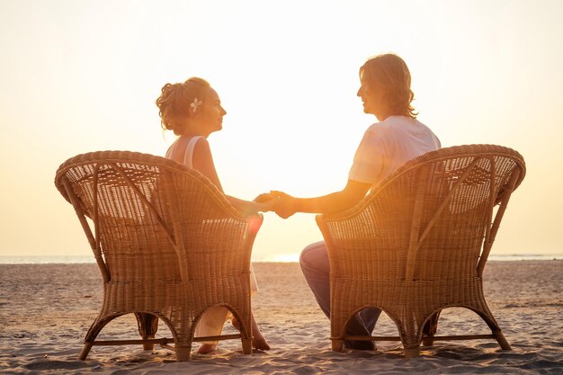 Heureux couple amoureux se reposer ensemble sur la plage près de l'océan ou de la mer concept d'assurance voyage