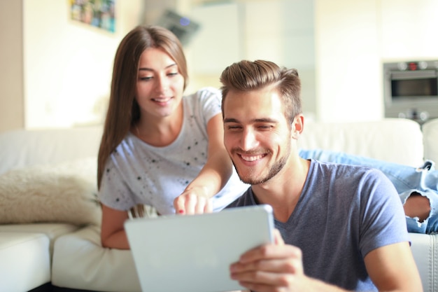 Heureux couple amoureux surf sur tablette à la maison