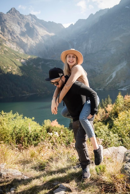 Heureux couple d'amoureux de touristes marchant dans les montagnes en profitant de la vue