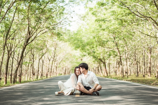 Heureux couple asiatique amoureux sur route avec arche d'arbre