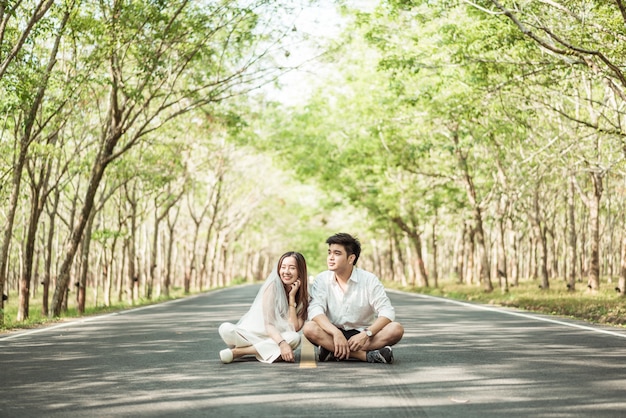 Heureux couple asiatique amoureux sur route avec arche d'arbre