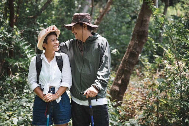 Heureux couple asiatique trekking dans le bois