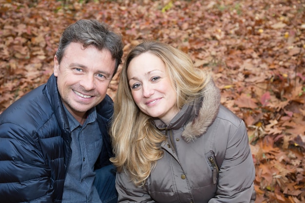 Heureux couple assis sur un banc automne nature