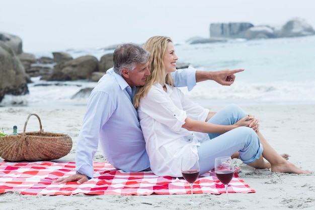 Heureux couple assis sur une couverture et se serrant les uns les autres