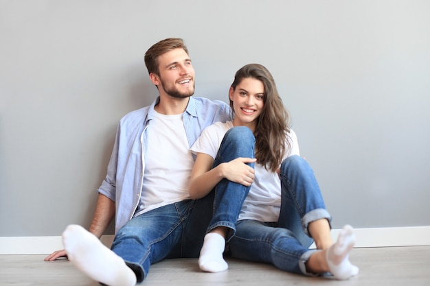 L'heureux couple assis sur le fond du mur gris.