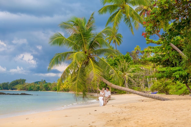 Heureux Couple Assis Sur La Plage Ensoleillée