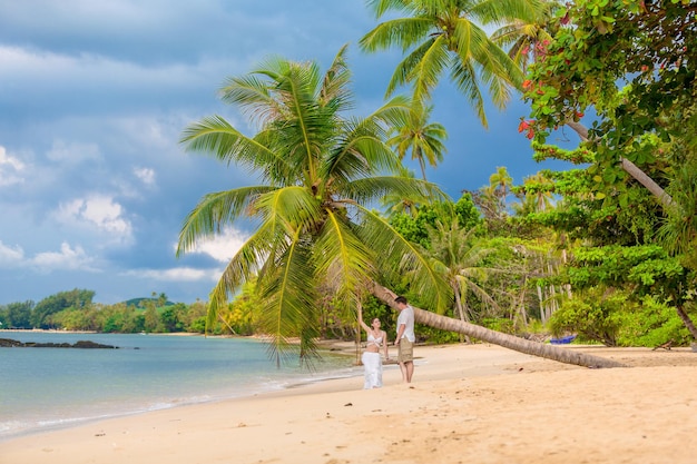 Heureux couple assis sur la plage ensoleillée