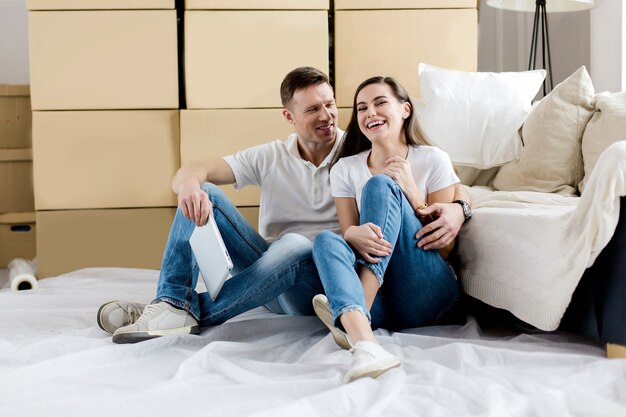 Heureux couple assis près de boîtes dans un nouvel appartement. photo avec espace de copie