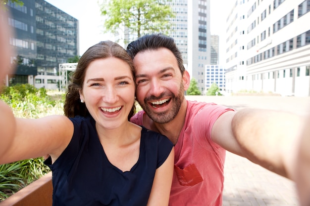 Heureux couple attrayant prenant selfie à l&#39;extérieur de la ville