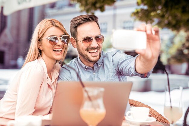 Heureux couple au café prenant selfie