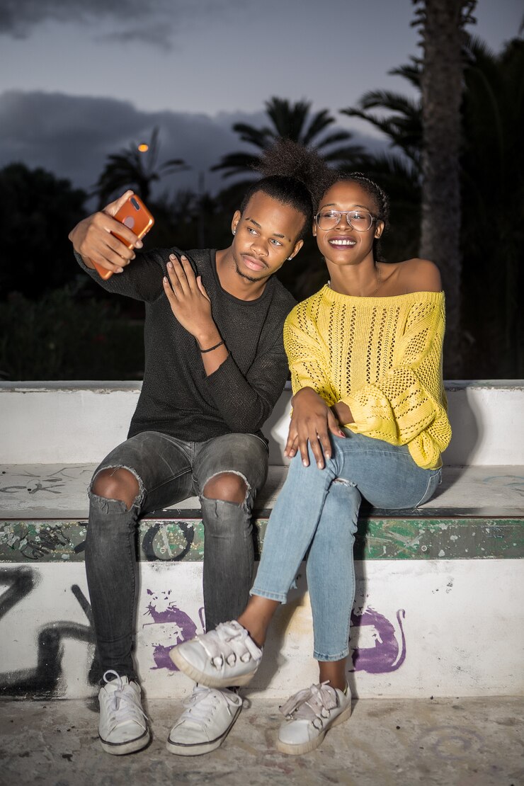 Heureux couple branché prenant selfie dans la nuit