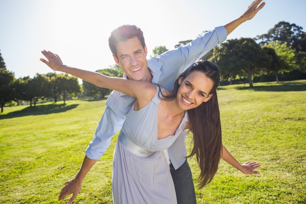 Heureux couple avec les bras tendus au parc