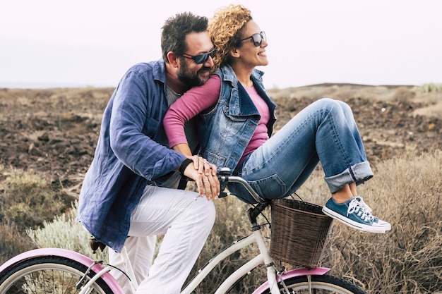 Photo heureux couple caucasien adulte s'amusant à vélo dans des activités de loisirs de plein air personnes actives