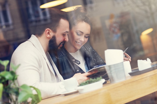 Heureux couple choisissant dans le menu du restaurant