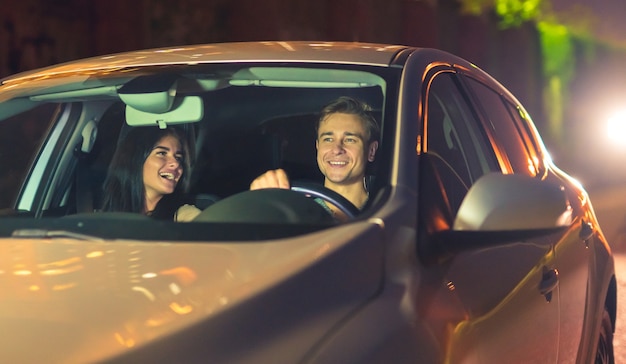 L'heureux couple conduit la voiture. le soir la nuit