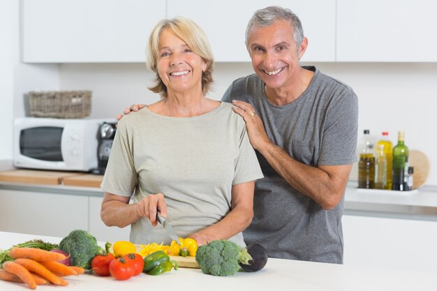 Heureux couple couper les légumes ensemble