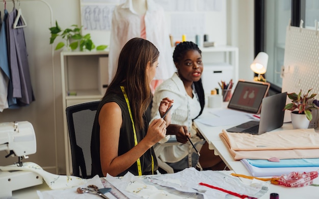 Heureux couple de créateurs de mode travaillant ensemble dans un studio d'atelier