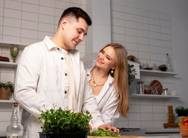 Heureux couple cuisiner à la maison concept d'aliments sains bel homme et jolie jeune femme faisant fre