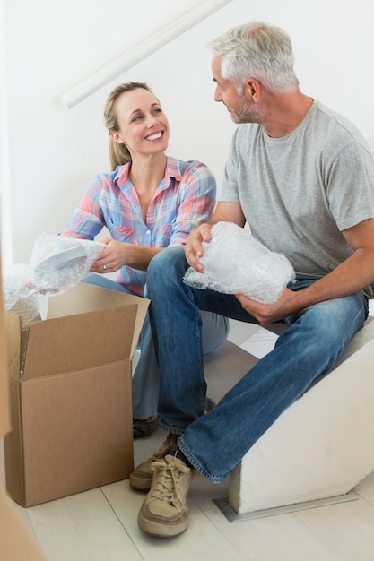 Heureux couple déballage des boîtes de déménagement en carton